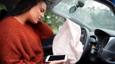 Woman inside her car with activated air bag aching