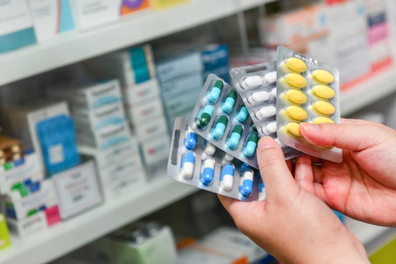 Hand holding medicine capsule pack at the drugstore