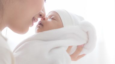 Mom holding newborn baby close