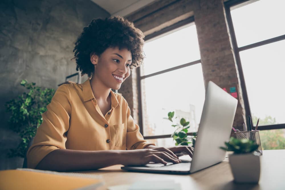 smiling auto insurance agent looking for discounts on her computer