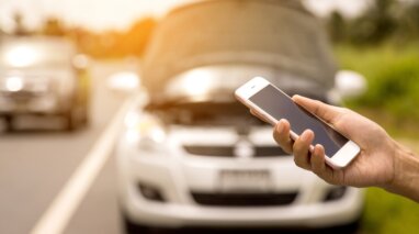 Using a mobile phone call a car mechanic because car was broken