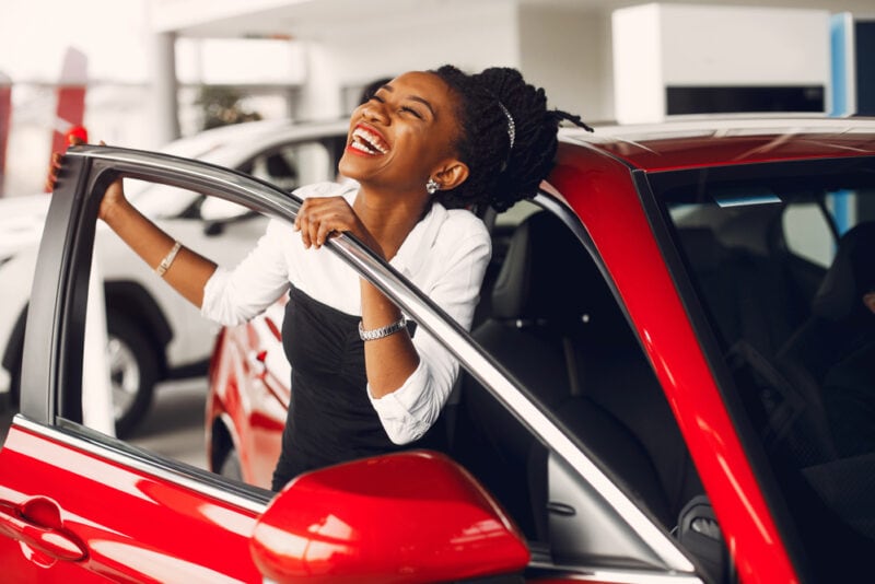 african american woman smiling by new car