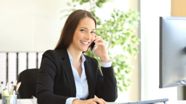 female insurance agent on phone at her desk with client