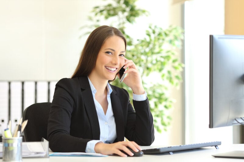 female insurance agent on phone at her desk with client