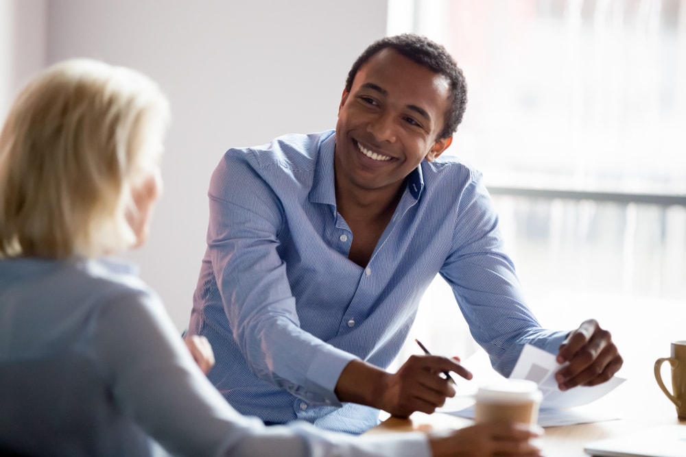 African American man selling insurance to Anglo woman