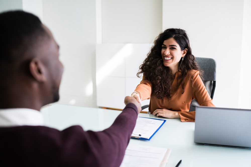 female insurance agent shaking hand with client