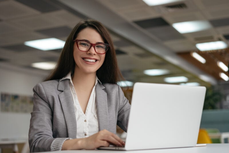 insurance agent smiling next to laptop