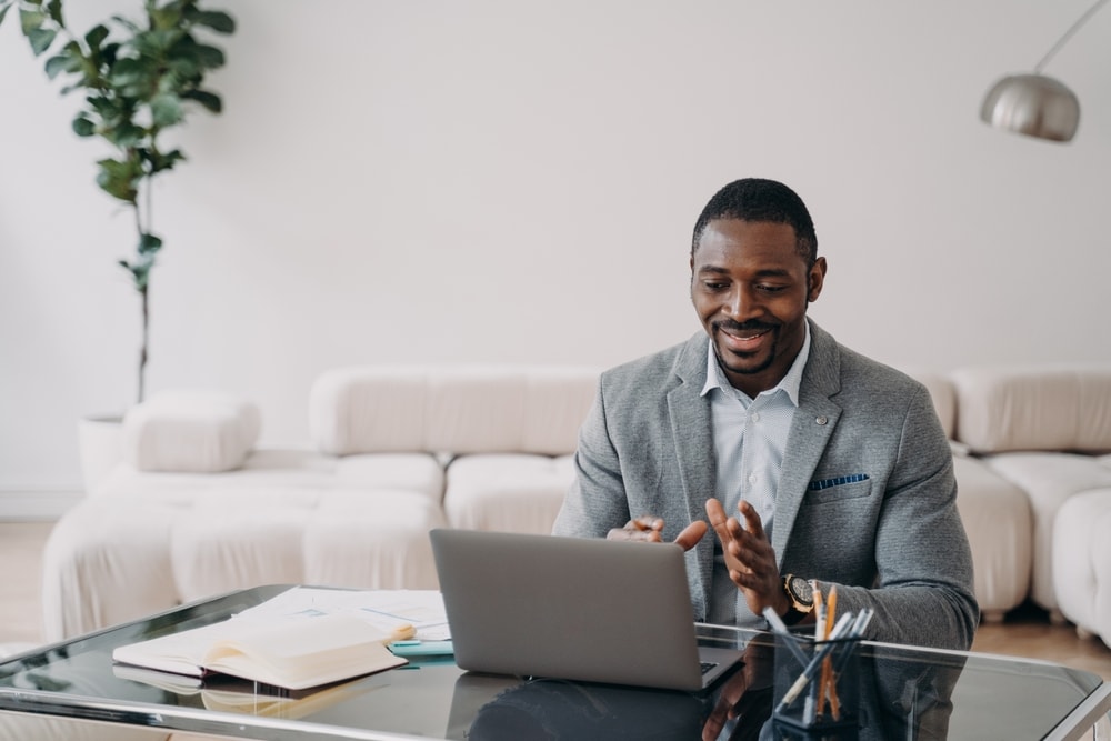 African-American insurance agent sits in front of laptop