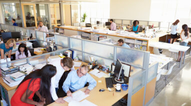 View from above of a happy bustling office space with workers