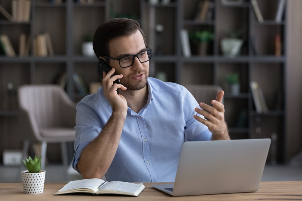 Male insurance agent on phone reaching out to customers - independent agent auto insurance