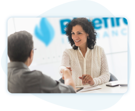 Businesswoman sitting behind desk in front of Bluefire sign shaking hands with man.